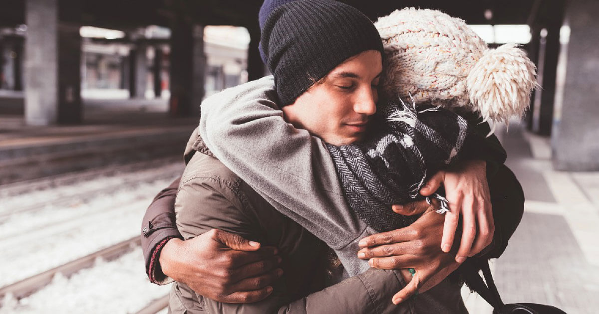Two people warmly embracing outdoors, showing support, connection, and a sense of emotional reassurance.